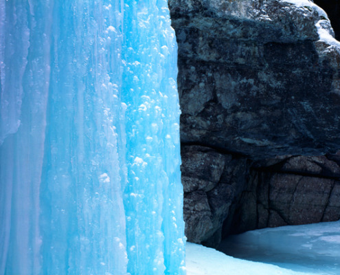 The iridescent blue of a frozen waterfall, suspended in this haunting canyon in the cold depth of winter. Jasper National Park.